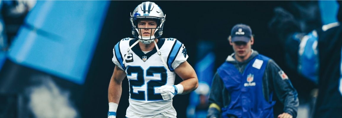 Will Allen in NFL crew uniform walking behind Carolina Panthers football player