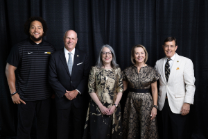 Photo of four alumni award winners with Chancellor Norris in the center
