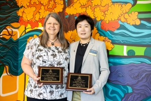 Two Award Winners Holding Plaques